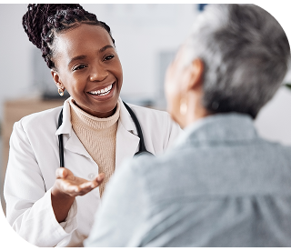 A doctor holds her hand up as she speaks with a patient.